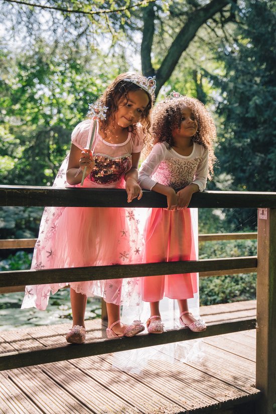 Twee meisjes verkleed als prinses die lachend op een brug staan